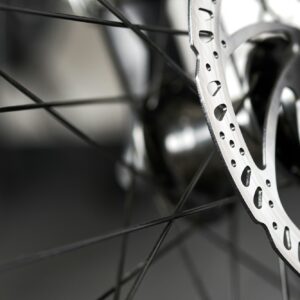 Bicycle disk brakes close up, metal disc attached to bike wheel, effective mountain bicycle brakes